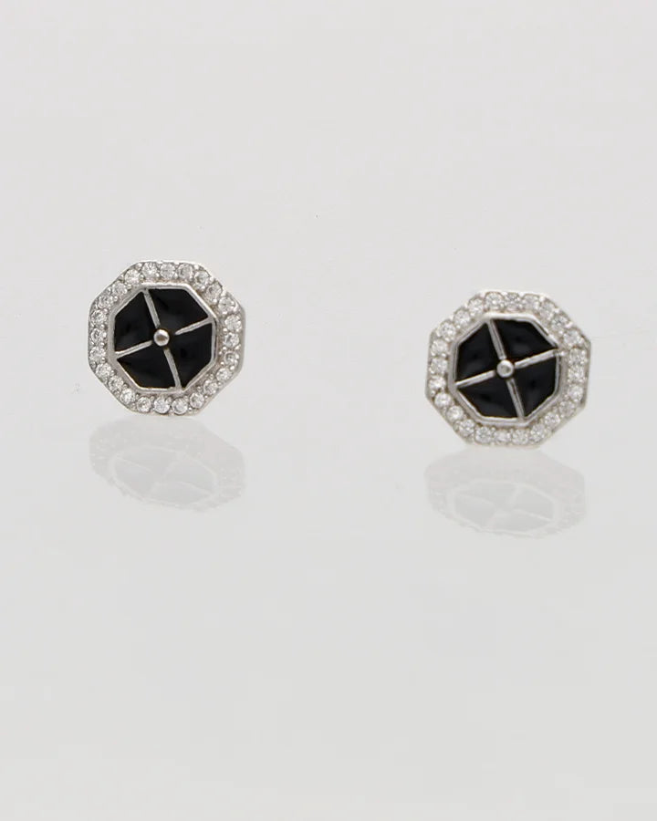 Pair of hexagonal earrings with black centers on a light gray background