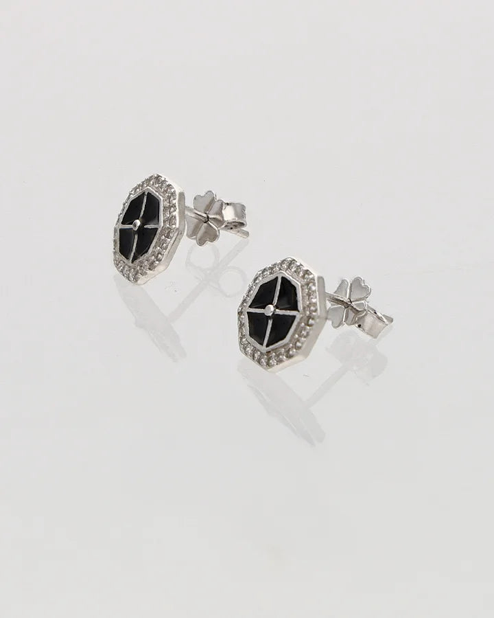 Pair of earrings with black and silver design on a light gray background