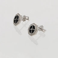 Pair of earrings with black and silver design on a light gray background