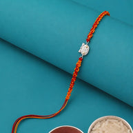 An orange and red braided Rakhi with a silver-toned owl charm.