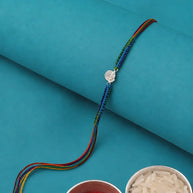A traditional Indian beaded bracelet (rakhi) with a silver Swastika symbol.