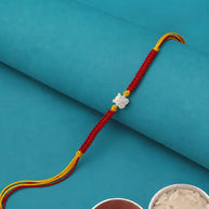A red braided Rakhi bracelet with a silver-toned elephant charm and yellow accents