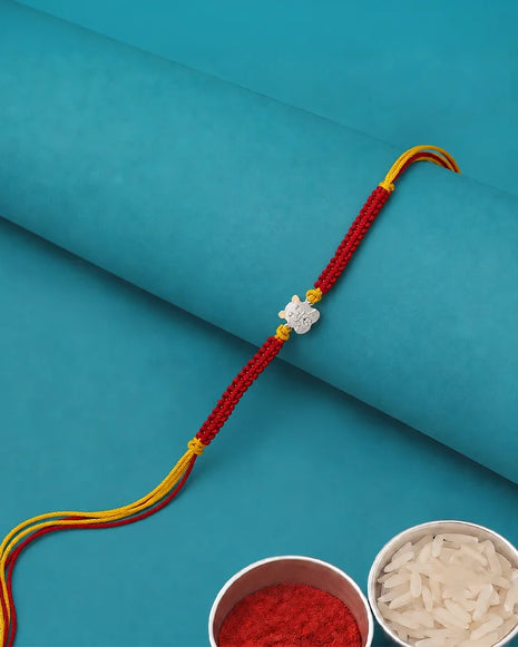 A red braided Rakhi bracelet with a silver-toned elephant charm and yellow accents